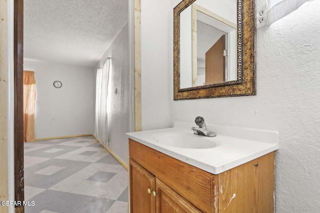 12365 Stubbs Dr, San Elizario, TX 79849 - bathroom featuring tile patterned floors, a textured wall, vanity, and a textured ceiling