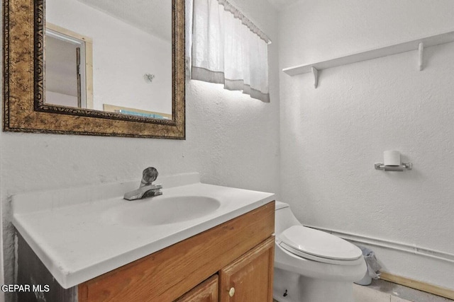 12365 Stubbs Dr, San Elizario, TX 79849 - half bath with vanity, a textured wall, and toilet