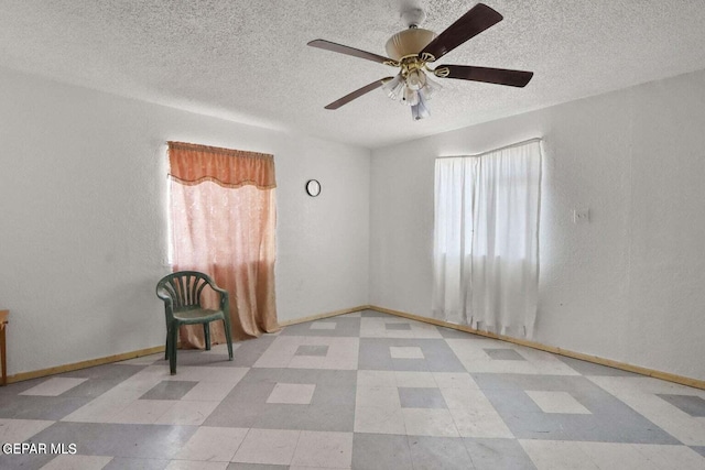 12365 Stubbs Dr, San Elizario, TX 79849 - spare room with baseboards, a ceiling fan, a textured ceiling, and tile patterned floors