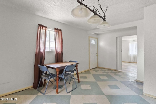 12365 Stubbs Dr, San Elizario, TX 79849 - dining area with a textured ceiling, tile patterned floors, and baseboards