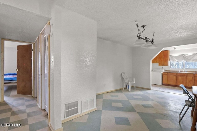 12365 Stubbs Dr, San Elizario, TX 79849 - interior space featuring light floors, a textured ceiling, and washer / clothes dryer