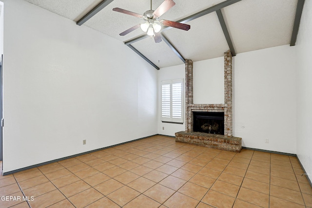 unfurnished living room with a brick fireplace, a ceiling fan, beamed ceiling, and a textured ceiling
