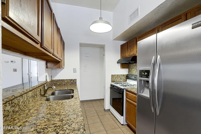 kitchen with visible vents, stainless steel refrigerator with ice dispenser, under cabinet range hood, a sink, and gas stove