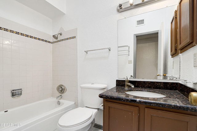 bathroom with shower / bathing tub combination, visible vents, vanity, toilet, and a textured wall