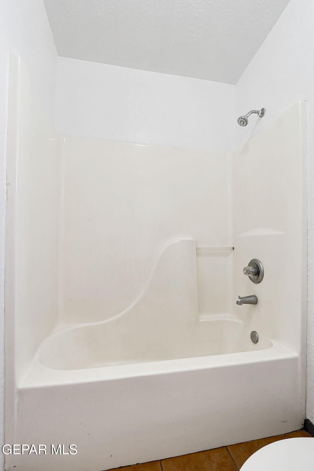full bath with tile patterned flooring, shower / bathtub combination, and toilet