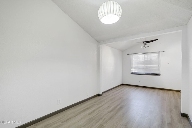 empty room featuring light wood-type flooring, baseboards, ceiling fan, and lofted ceiling