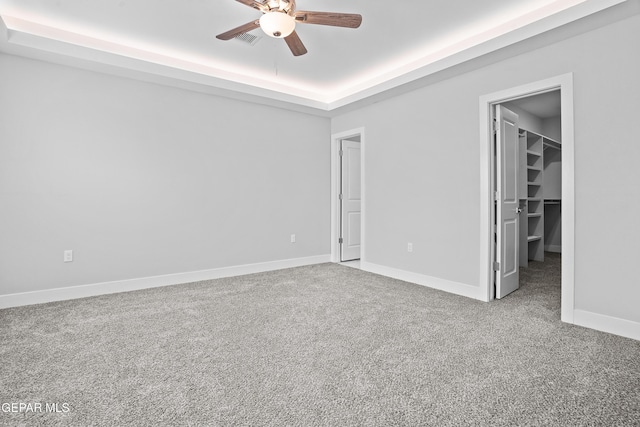 478 Sylvia Ct, Socorro, TX 79927 - unfurnished bedroom with a walk in closet, carpet flooring, a raised ceiling, and a ceiling fan