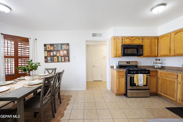 9232 Morelia Rd, El Paso, TX 79907 - kitchen featuring stainless steel range with gas cooktop, light tile patterned flooring, visible vents, black microwave, and baseboards