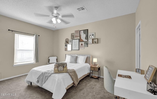 bedroom with visible vents, carpet flooring, a textured ceiling, and a ceiling fan