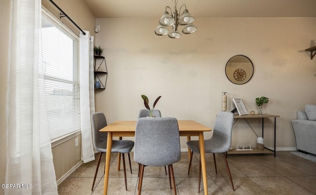 dining area featuring tile patterned floors, a notable chandelier, and baseboards