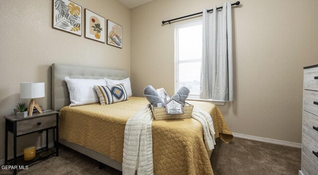 bedroom featuring dark carpet and baseboards