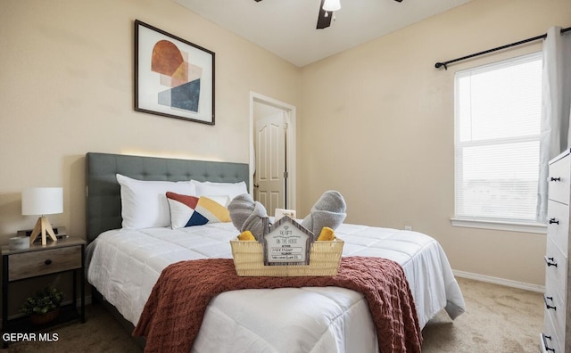 carpeted bedroom featuring baseboards, multiple windows, and ceiling fan