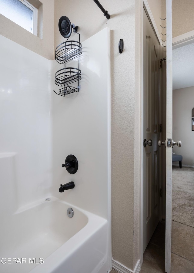 bathroom with baseboards and shower / washtub combination