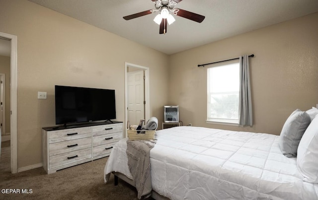 carpeted bedroom featuring baseboards and a ceiling fan