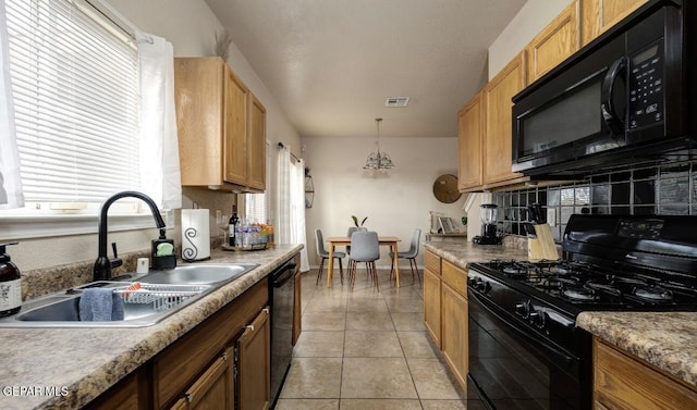 kitchen with a sink, decorative light fixtures, light tile patterned floors, visible vents, and black appliances