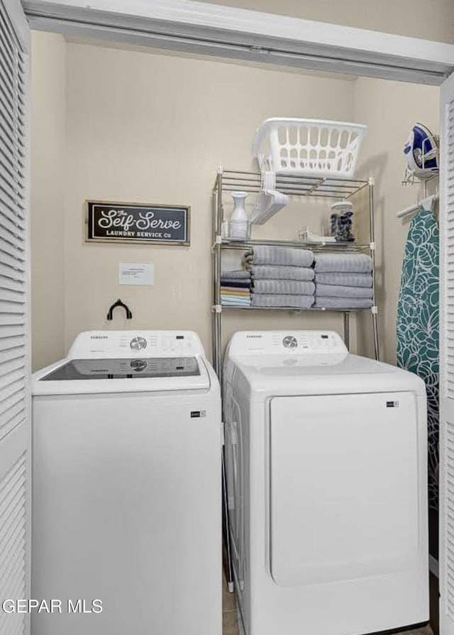 clothes washing area featuring laundry area and washing machine and clothes dryer
