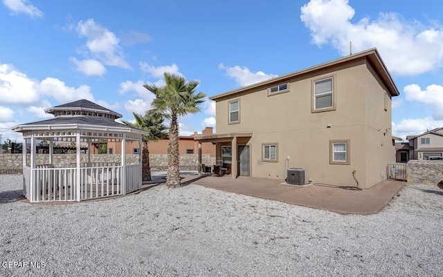 rear view of house featuring central AC unit, a patio area, a gazebo, fence, and stucco siding