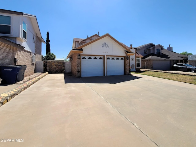 10812 Sandy Koufax Dr, El Paso, TX 79924 - view of front of home featuring an attached garage, fence, brick siding, and concrete driveway
