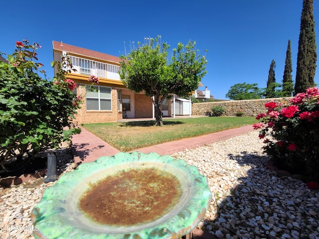 10812 Sandy Koufax Dr, El Paso, TX 79924 - back of house featuring a lawn, brick siding, an outdoor structure, and a shed