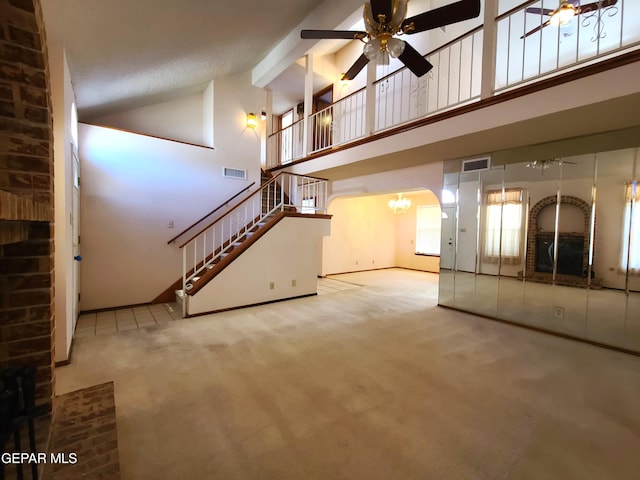10812 Sandy Koufax Dr, El Paso, TX 79924 - unfurnished living room featuring visible vents, carpet floors, high vaulted ceiling, ceiling fan with notable chandelier, and stairs