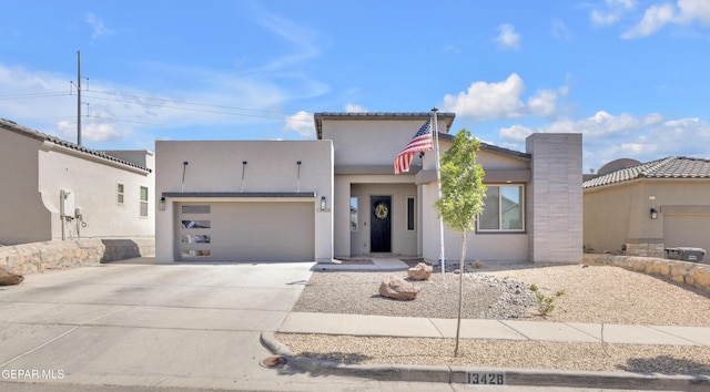 view of front of house featuring an attached garage, concrete driveway, and stucco siding