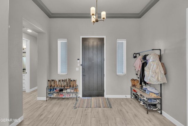 entrance foyer featuring baseboards, wood finished floors, and an inviting chandelier