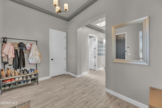 foyer entrance featuring baseboards, wood finished floors, and an inviting chandelier
