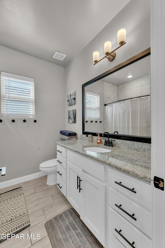 full bathroom featuring vanity, plenty of natural light, toilet, and visible vents