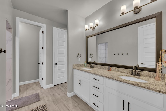 full bathroom with a sink, baseboards, and double vanity