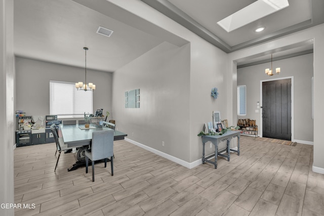 dining room with an inviting chandelier, baseboards, wood finished floors, and visible vents