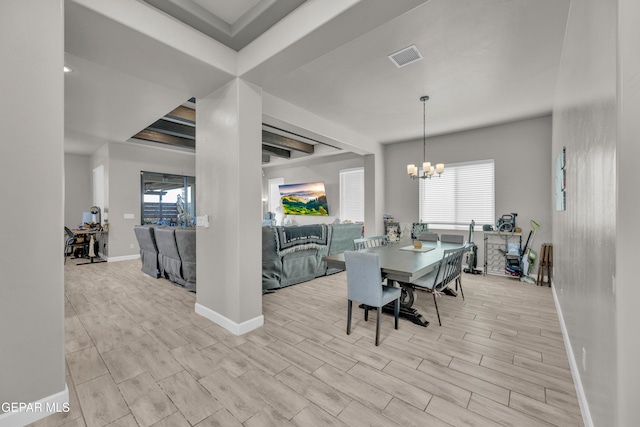 dining area featuring baseboards, a notable chandelier, wood finish floors, and visible vents