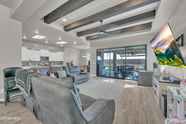 living area featuring visible vents, beamed ceiling, baseboards, recessed lighting, and light wood finished floors