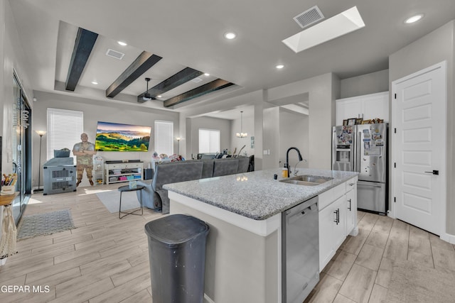 kitchen with visible vents, a sink, open floor plan, and stainless steel appliances
