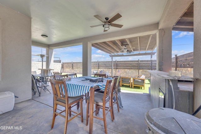 view of patio / terrace with fence, a ceiling fan, and outdoor dining space