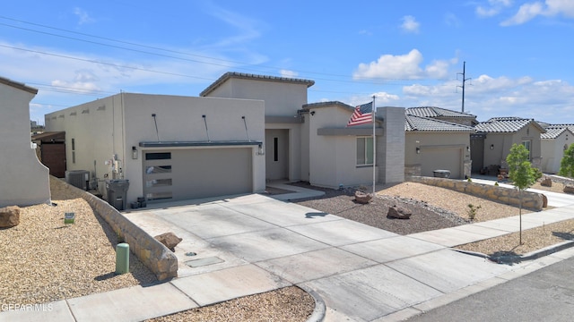 view of front facade featuring a garage, stucco siding, concrete driveway, and cooling unit
