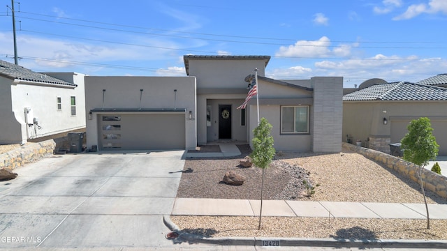 view of front of house with a garage, stucco siding, and concrete driveway