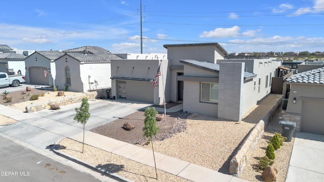 view of front facade featuring concrete driveway, a tiled roof, and stucco siding