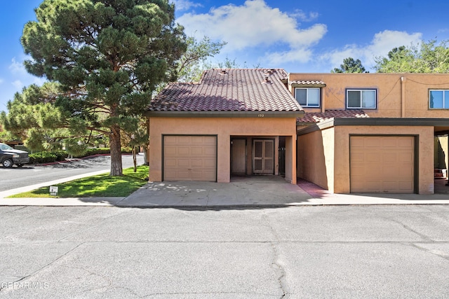 townhome / multi-family property featuring stucco siding and a tile roof