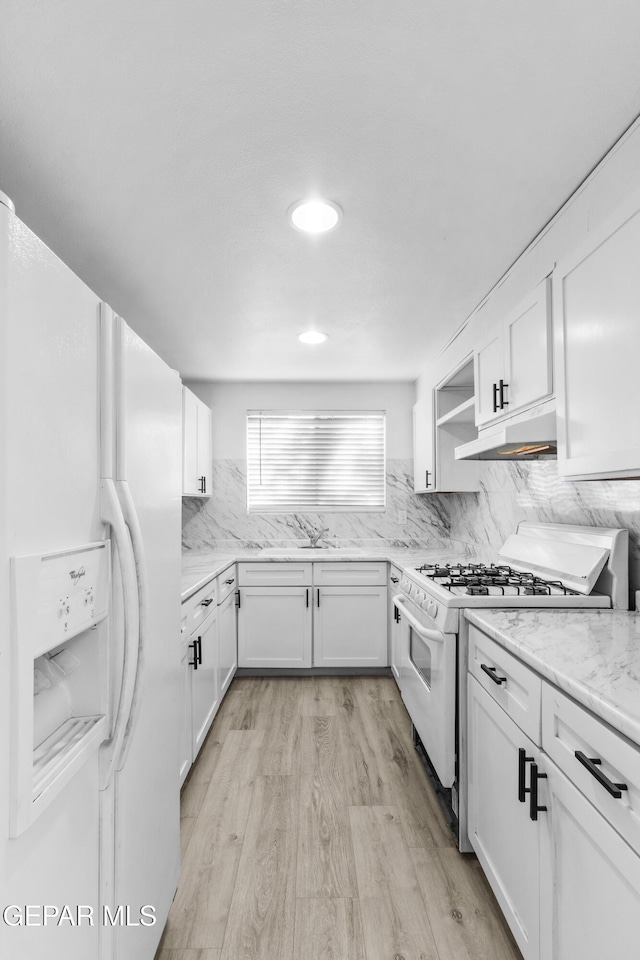 kitchen with open shelves, white cabinets, light wood-style floors, under cabinet range hood, and white appliances