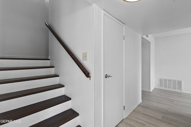 stairs with visible vents, baseboards, and wood finished floors