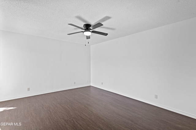 empty room featuring a textured ceiling, ceiling fan, dark wood-style floors, and baseboards