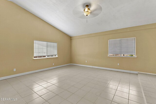 tiled spare room featuring baseboards, ceiling fan, and vaulted ceiling