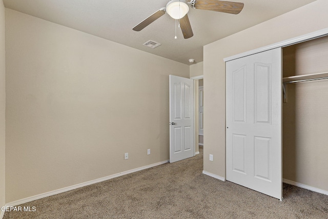unfurnished bedroom with ceiling fan, light colored carpet, baseboards, visible vents, and a closet