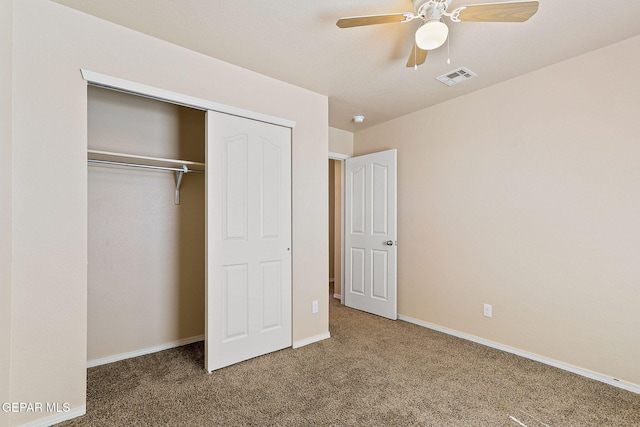 unfurnished bedroom featuring carpet, a ceiling fan, baseboards, visible vents, and a closet