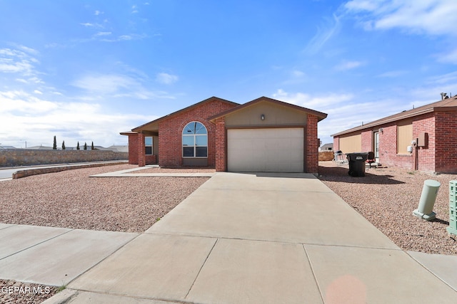 ranch-style house featuring concrete driveway, brick siding, and an attached garage