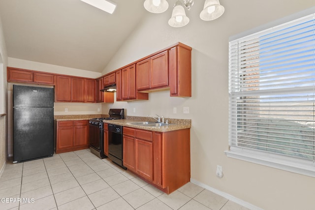 kitchen with under cabinet range hood, a sink, light tile patterned floors, black appliances, and vaulted ceiling