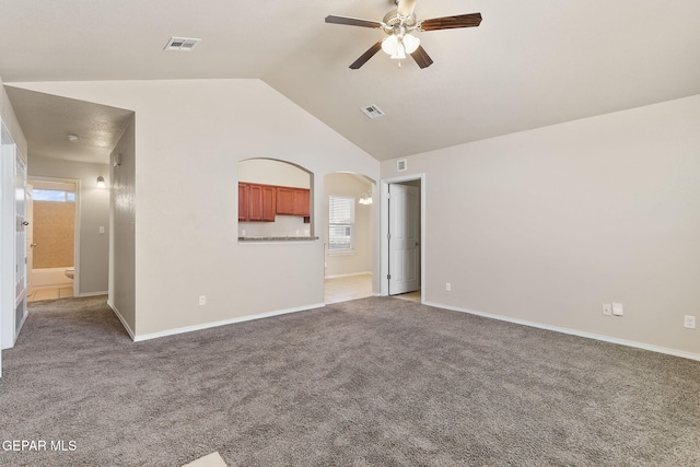 unfurnished living room featuring visible vents, ceiling fan, vaulted ceiling, and carpet floors