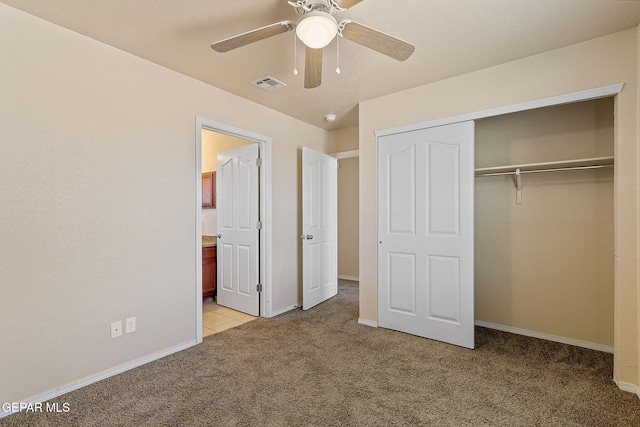 unfurnished bedroom featuring connected bathroom, light colored carpet, baseboards, visible vents, and a closet