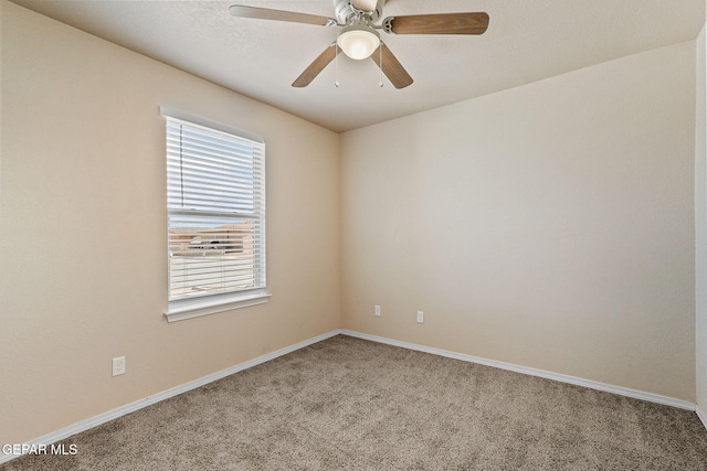 carpeted spare room with baseboards and a ceiling fan