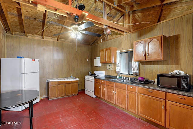 19201 Phillip Bazaar, El Paso, TX 79938 - kitchen featuring dark floors, dark countertops, brown cabinetry, and white appliances